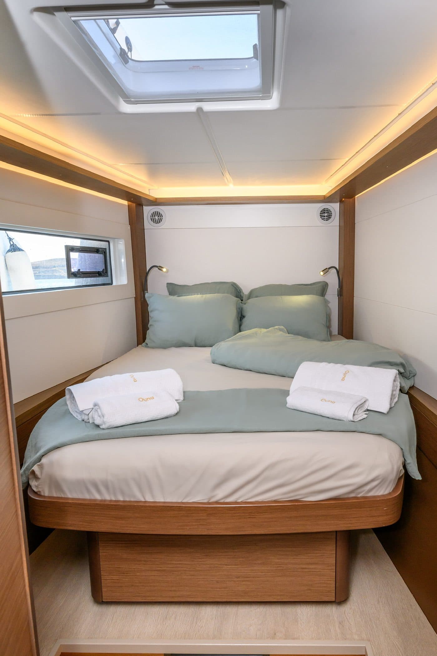 Guest cabin with sage linen and a skylight opening to the rigging above