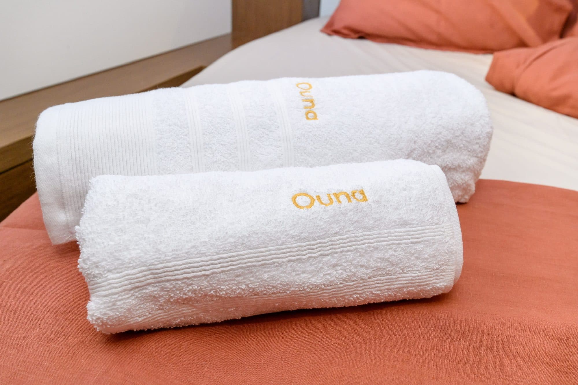 Ouna-embroidered towels folded on a freshly made bed