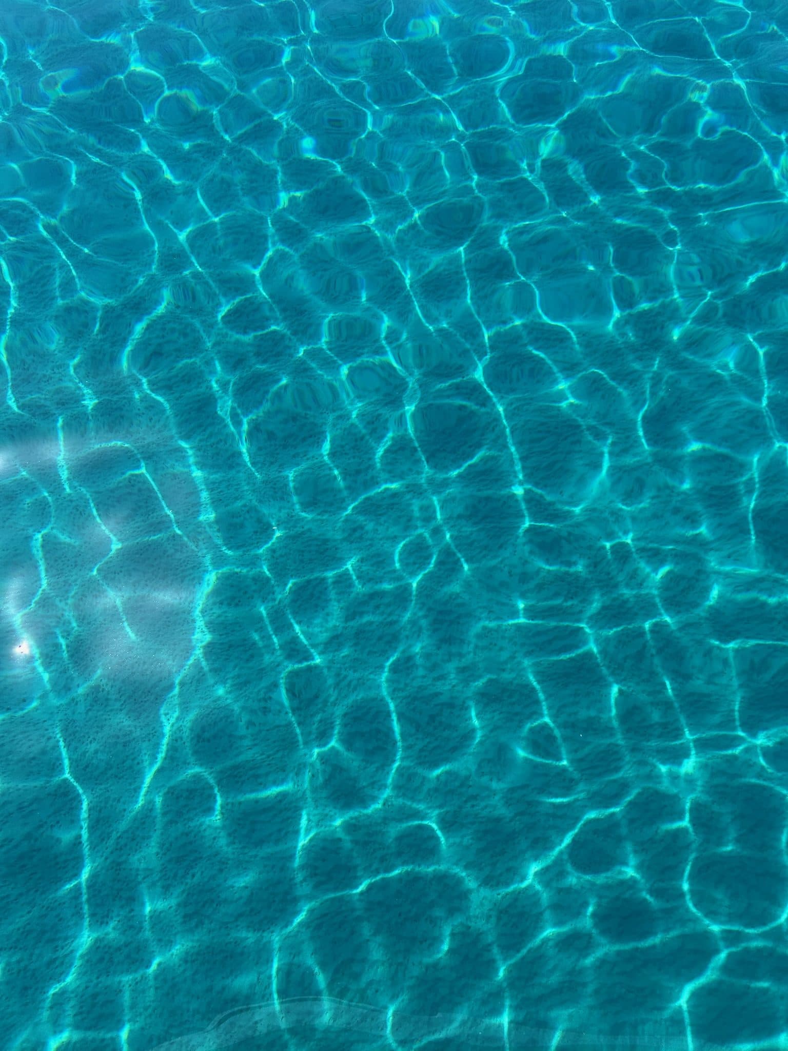 Crystal-clear turquoise water over a sandy bottom — your morning swim