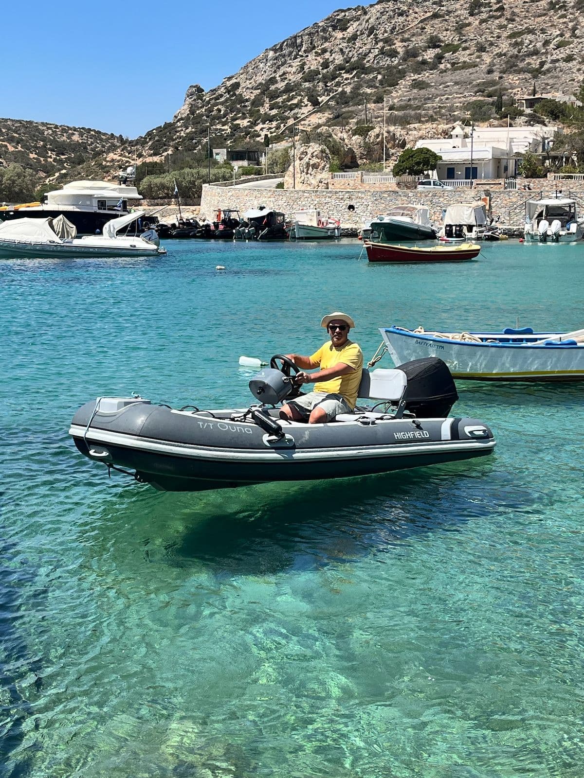 Nikos on the dinghy in a Cycladic harbour